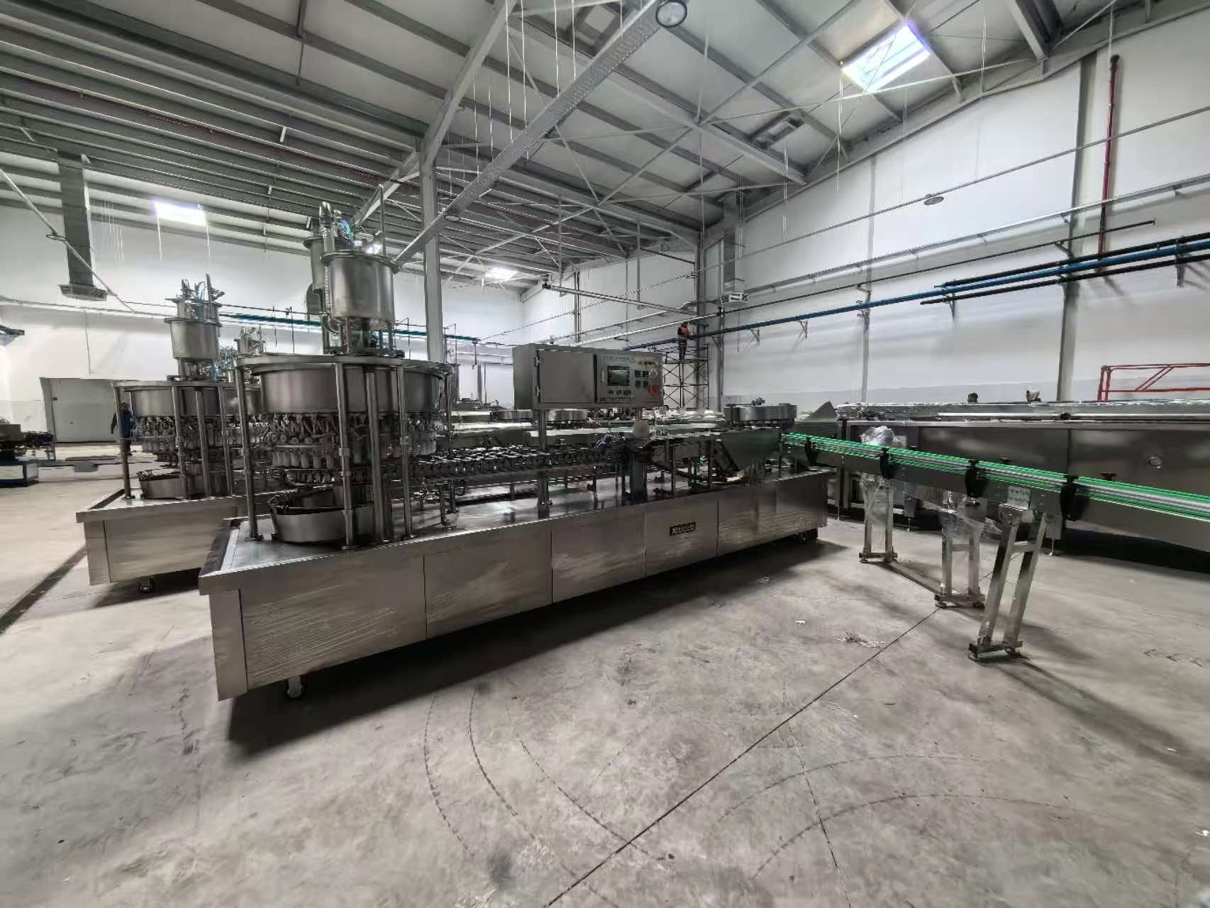 Beverage factory with XC Machinery spout pouch filling and capping equipment